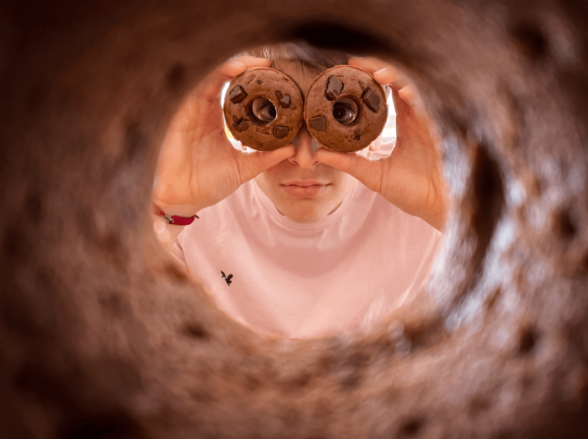 The Doughnana founder holding two Doughnanas over his eyes, photographed through a Doughnana